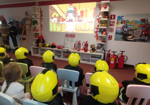 Dzieci oglądają film edukacyjny o przygodach Floriana strażaka.