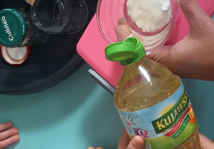 Dziecko wlewa do szklanki z sodą olej
