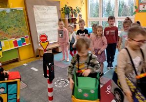 Dzieci poruszają się na makiecie zgodnie z przepisami ruchu drogowego.