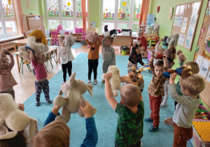 Dzieci tańczą z misiami na dywanie
