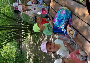 Dzieci siedzą przy stole i jedzą słodkie przekąski