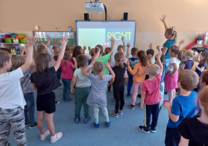 Dzieci podnoszą prawą rękę do góry podczas zabawy ruchowej w języku angielskim