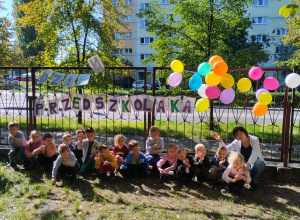 Dzieci pozują do grupowego zdjęcia w ogrodzie przedszkolnym