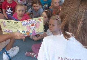 Dzieci słuchają opowiadania o przygodach myszki Molly
