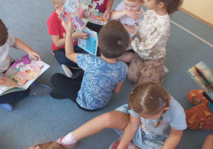Dzieci oglądają książeczki o przygodach myszki Molly