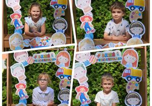 Dzieci pozują w fotobudce z napisem Dzień Przedszkolaka
