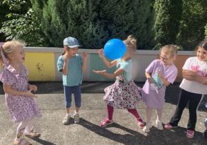 Dzieci przy muzyce przekazują sobie rekwizyt- balon