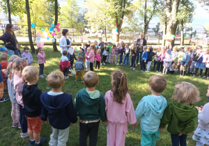 Dzieci stoją w kole i śpiewają piosenkę