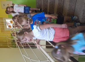 Dzieci schodzą po schodach trzymając się poręczy