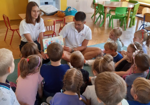 Dzieci słuchają bajki czytanej przez studenta