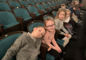 Dzieci siedzą na widowni teatru "Piccolo" w oczekiwaniu na rozpoczęcie przedstawienia