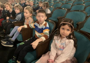 Dzieci siedzą na widowni teatru "Piccolo"