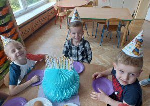 Chłopcy przy urodzinowym torcie z papieru