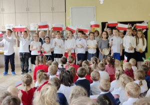 Dzieci śpiewają piosenkę pt.:"Jaki piękny kraj" trzymając flagę Polski
