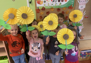 Dzieci pozują z papierowymi kwiatami