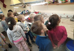 Dzieci oglądają proces ręcznego zdobienia bombek.