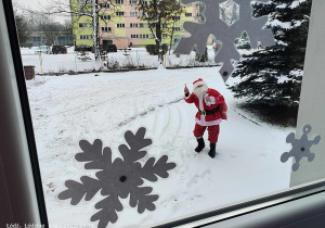 Mikołaj macha do dzieci za oknem