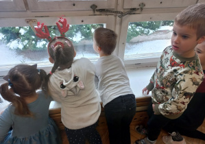Dzieci wypatrują Mikołaja przez okno