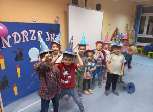 Dzieci pozują do grupowego zdjęcia w kapeluszach czarodziejów
