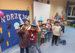Dzieci pozują do grupowego zdjęcia w kapeluszach czarodziejów