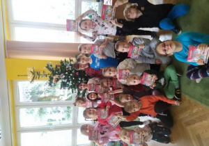 Grupowe zdjęcie dzieci z prezentami od Mikołaja.