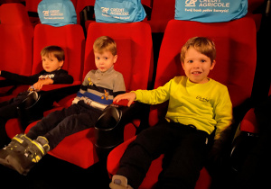 Chłopcy siedzą na kinowych fotelach