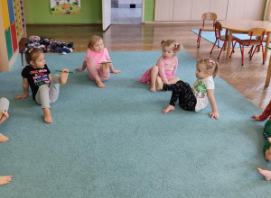 Dzieci ćwiczą z wykorzystaniem lasek gimnastycznych