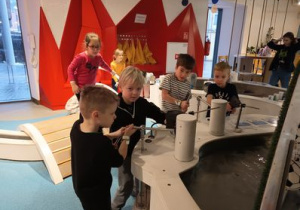 Dzieci z zaciekawieniem eksperymentują z wodą.
