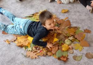 Chłopiec leży na liściach