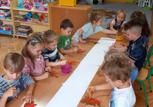 Dzieci malują farbami liście
