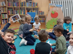 Dzieci siedzą w kole i słuchają wypowiedzi Pani z biblioteki