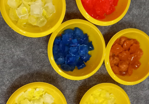 Kolorowe kostki lodu posegregowane w miseczkach