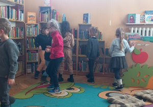 Dzieci szukają w bibliotece pochowanych sylwet pantofelków