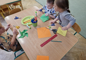 Dzieci wykonują wiatraczki z papieru i słomek do napojów.