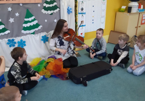 Dzieci słuchają jak pani gra na skrzypcach