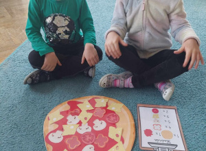 Dzieci prezentują swoją pizzę ułożoną zgodnie z warunkami