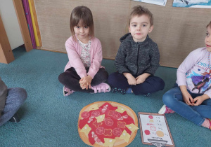 Dzieci prezentują swoją pizzę ułożoną zgodnie z podanymi składnikami