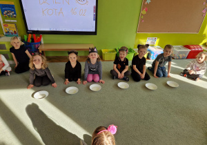 Dzieci szykują się do picia mleka z talerzyków