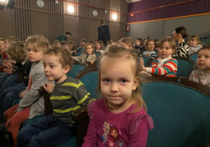 Dzieci siedzą na teatralnej widowni