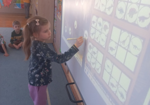 Dziewczynka uzupełnia sudoku na tablicy interaktywnej