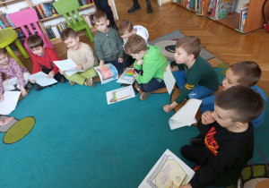 Dzieci prezentują zaprojektowane przez siebie okładki swoich ulubionych książek