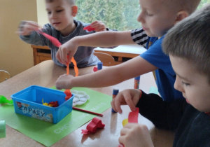 Dzieci wykonują smoka z rolki, papieru kolorowego i bibuły