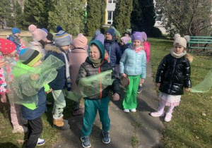 Dzieci tańczą z zielonymi apaszkami.