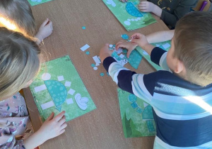 Dzieci układają mozaikę z figur "Dzinozaur"