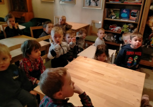 dzieci czekają przy stołach na przedstawienie
