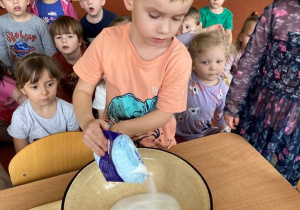 Chłopiec wsypuje sól do miski aby zrobić masą solną