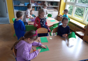 Dzieci rysują i wycinają szczypiorek dla cebuli z zielonego kartonu