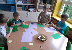 Chłopcy rysują i wycinają szczypiorek dla cebuli z zielonego kartonu