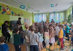 Dzieci słuchają gry na gitarze elektrycznej