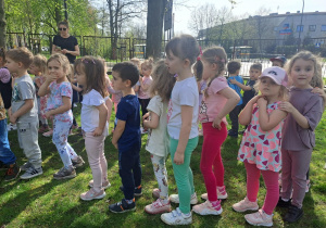 Dzieci z gr II stoją w rzędzie i słuchają instrukcji wykonania ćwiczenia